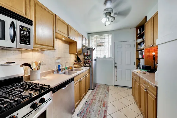 a kitchen with stainless steel appliances a sink stove top oven and cabinets