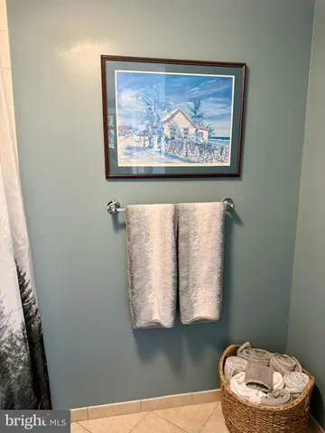 a bathroom with a toilet and a painting on the wall