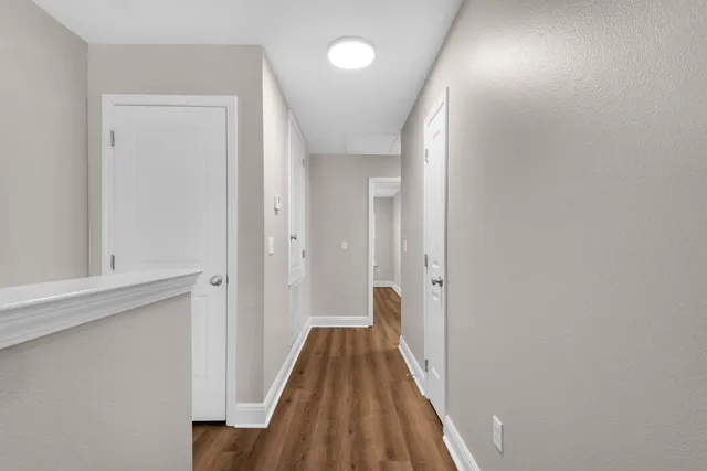 a view of a hallway with wooden floor