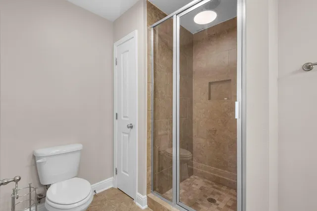 a bathroom with a toilet and a shower