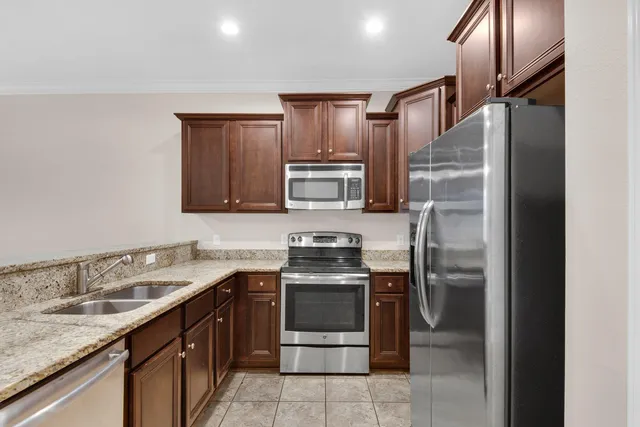 a kitchen with stainless steel appliances granite countertop a sink stove and refrigerator