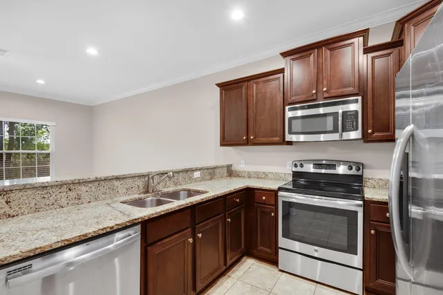 a kitchen with granite countertop a sink stove and microwave