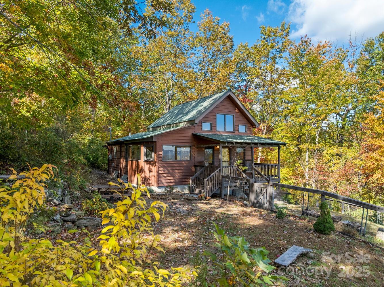 a view of wooden house with a yard and large trees