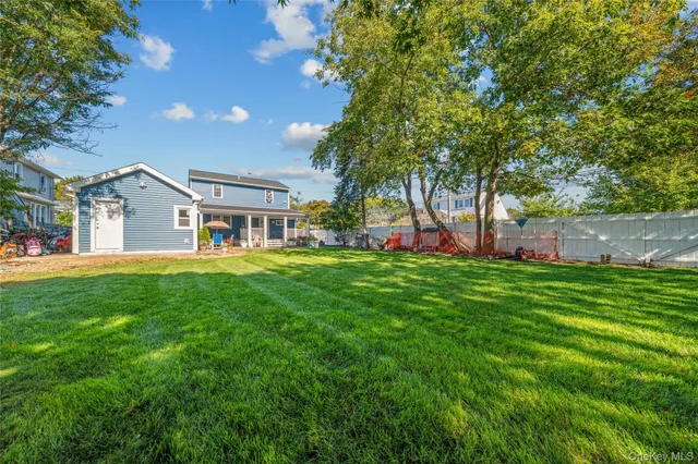a view of a house with a big yard and large trees
