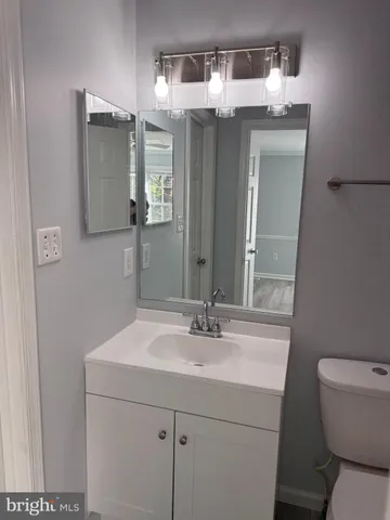 a bathroom with a toilet sink and mirror