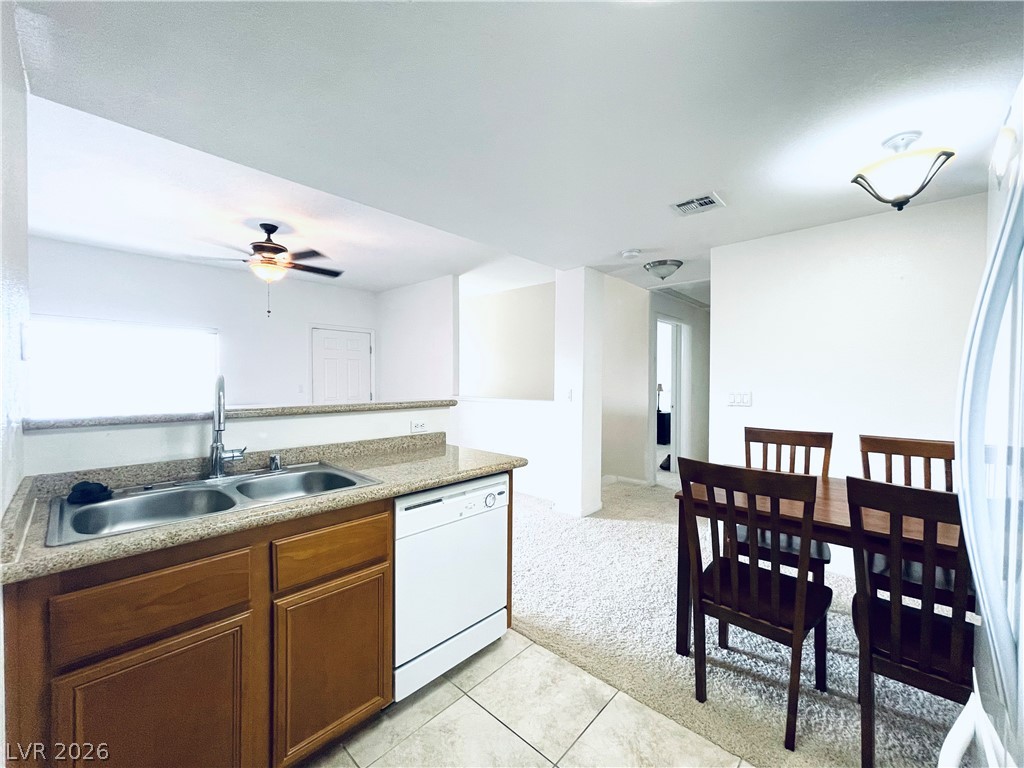7701 West Robindale Road, Unit 206 Las Vegas, NV 89113 - Photo 9 of 30 An open kitchen layout flows seamlessly into the dining area with durable tile flooring.
