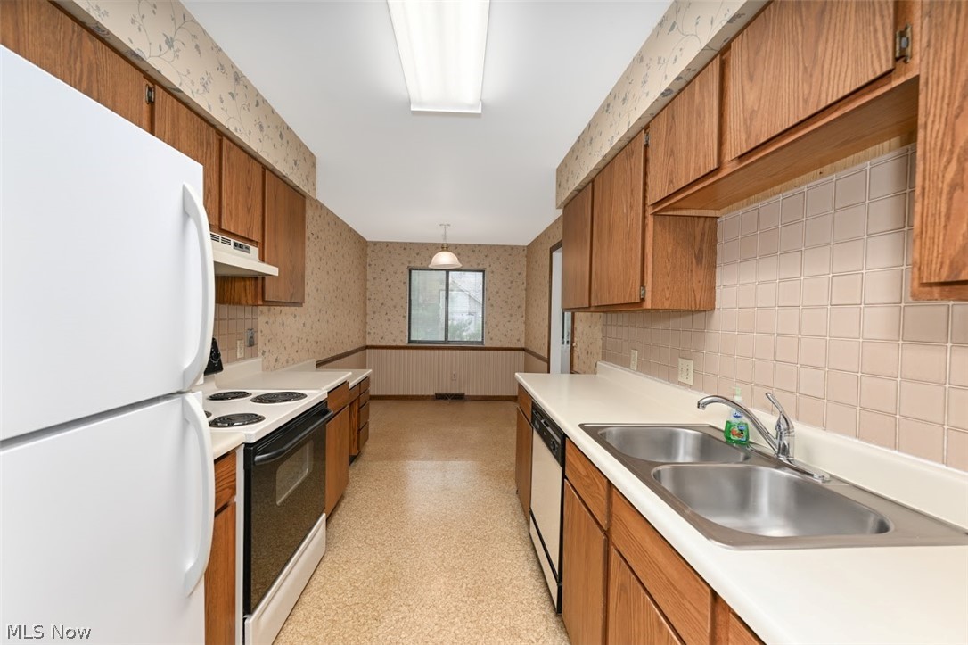 979 Hampton Ridge Drive Akron, OH 44313 - Photo 10 of 25 Kitchen with backsplash, sink, white appliances, and decorative light fixtures