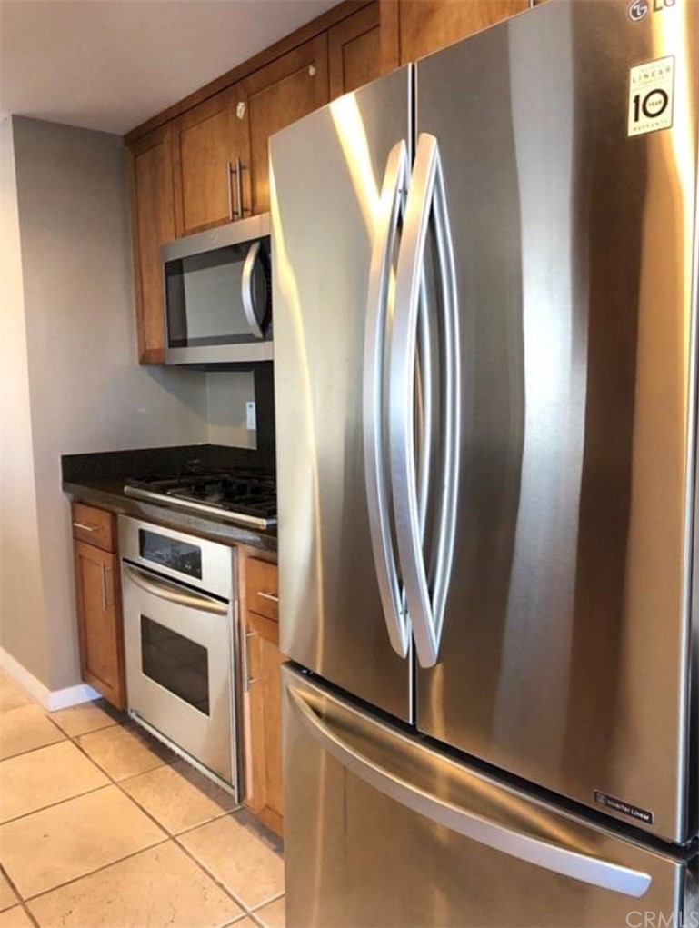 400 West Ocean Boulevard, Unit 206 Long Beach, CA 90802 - Photo 12 of 20 a view of a kitchen with a stove wooden cabinets and glass door