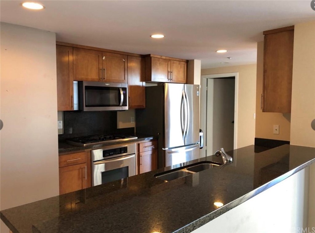 400 West Ocean Boulevard, Unit 206 Long Beach, CA 90802 - Photo 9 of 20 a kitchen with kitchen island a counter top space cabinets and stainless steel appliances