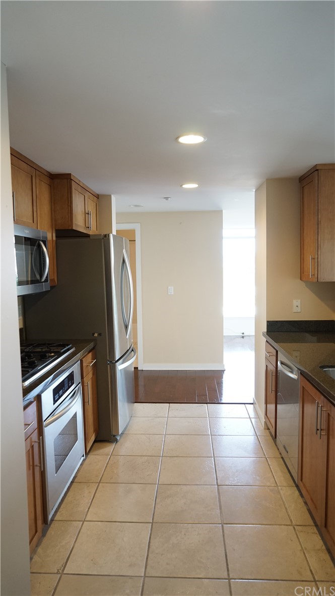 400 West Ocean Boulevard, Unit 206 Long Beach, CA 90802 - Photo 10 of 20 a kitchen with granite countertop a refrigerator and a stove top oven