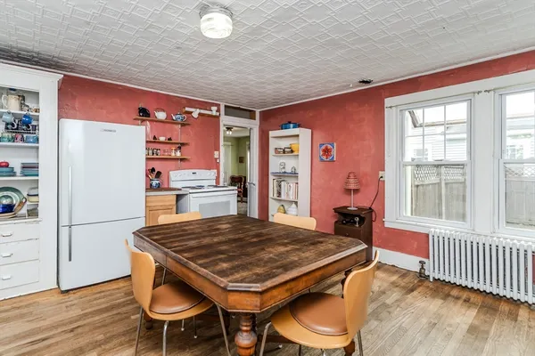 a living room with a table chairs and wooden floor
