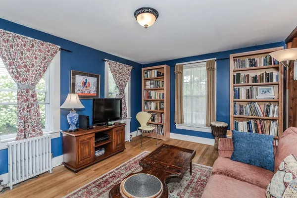 a living room with furniture a bookshelf and a flat screen tv