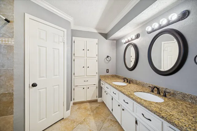 a bathroom with a granite countertop double vanity sink and a mirror