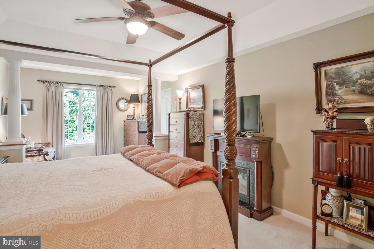 7315 Maplecrest Road, Unit 405 Elkridge, MD 21075 - Photo 23 of 76 a bedroom with a bed a flat screen tv and a chandelier