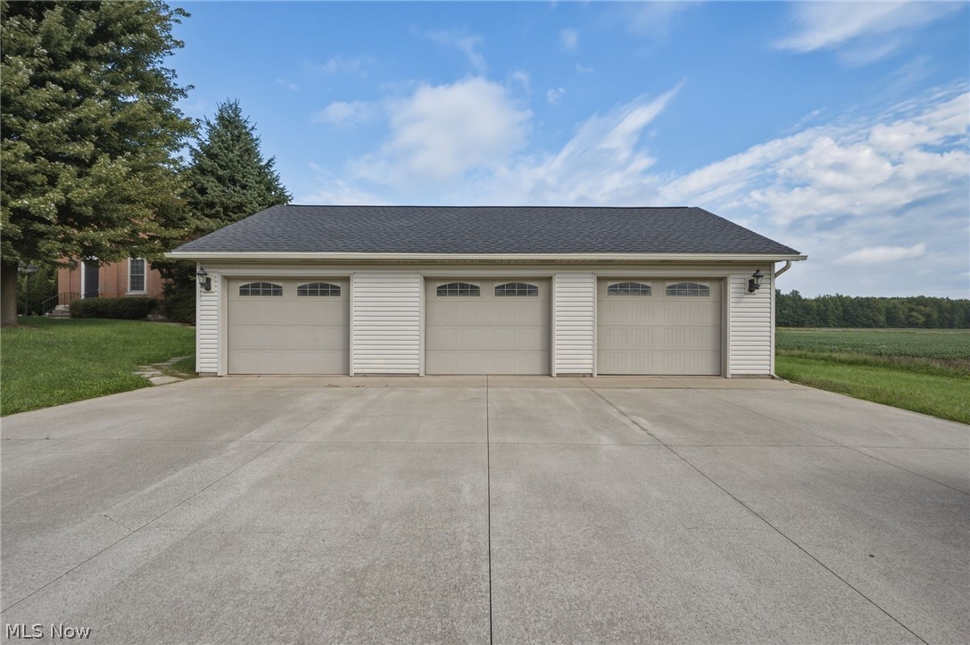 42764 Russia Road Elyria, OH 44035 - Photo 7 of 50 Three-car garage with white siding and gray garage doors