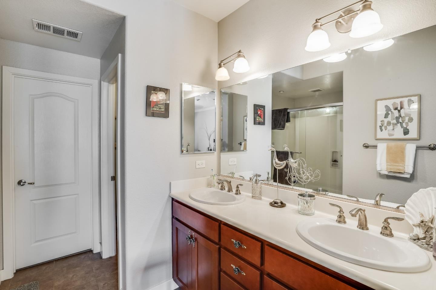 6132 Old Quarry Loop Oakland, CA 94605 - Photo 13 of 38 a bathroom with a double vanity sink a mirror and a shower
