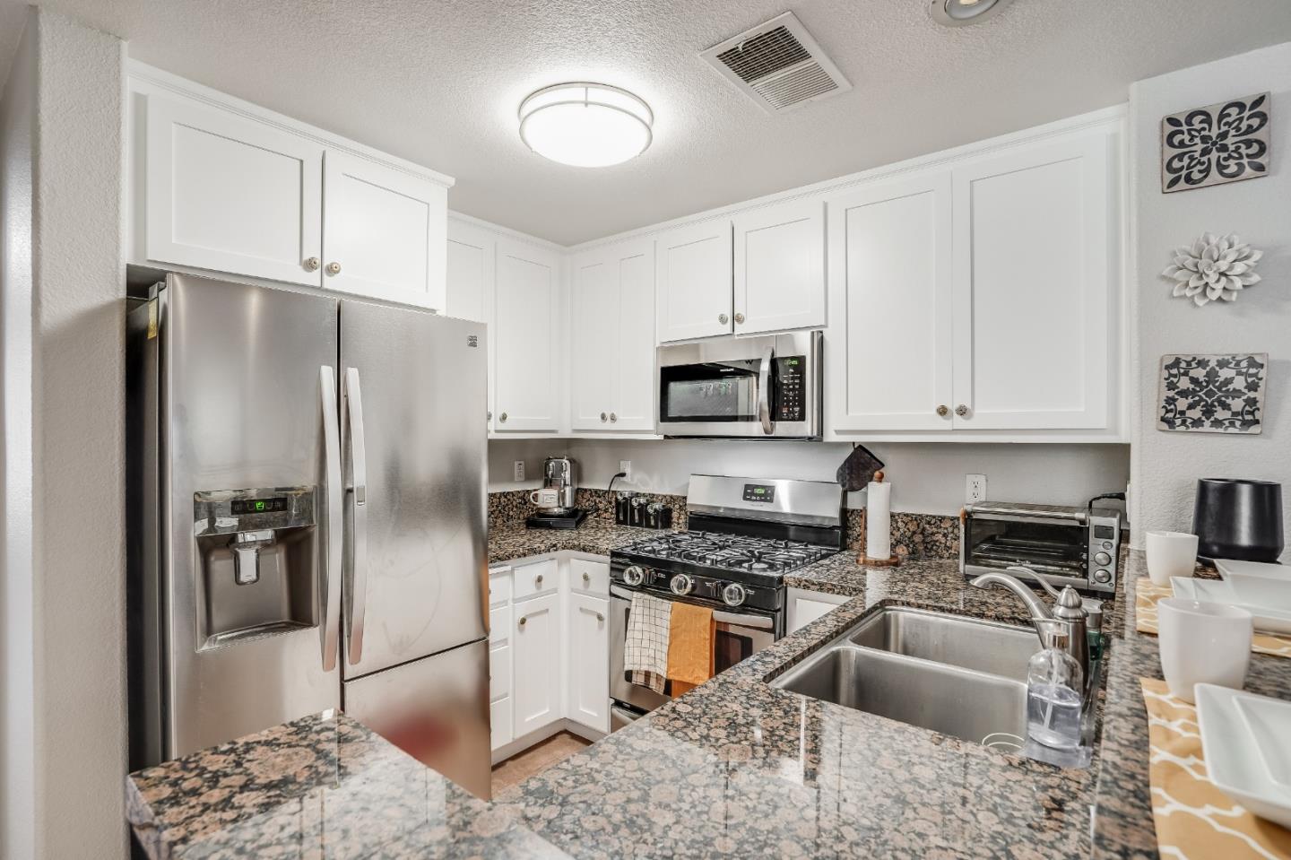 6132 Old Quarry Loop Oakland, CA 94605 - Photo 6 of 38 a kitchen with stainless steel appliances granite countertop a refrigerator a stove a sink and a microwave