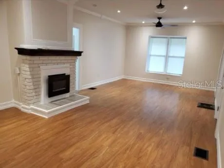 an empty room with wooden floor and a fireplace