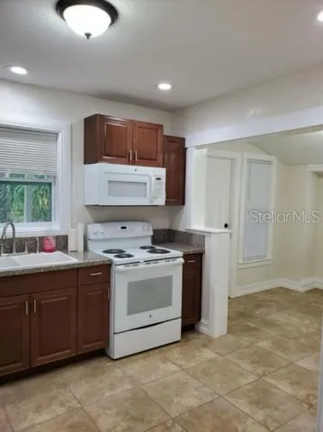 a kitchen with a stove sink and cabinets