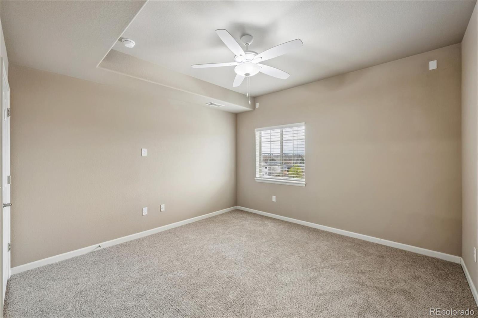 1044 Rockhurst Drive, Unit 404 Highlands Ranch, CO 80129 - Photo 21 of 28 an empty room with windows and fan