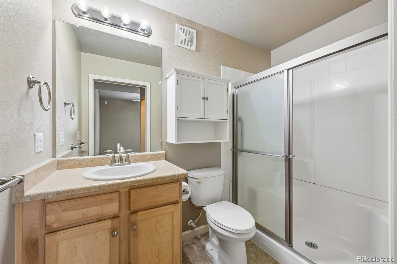 1044 Rockhurst Drive, Unit 404 Highlands Ranch, CO 80129 - Photo 23 of 28 a bathroom with a sink toilet vanity and shower