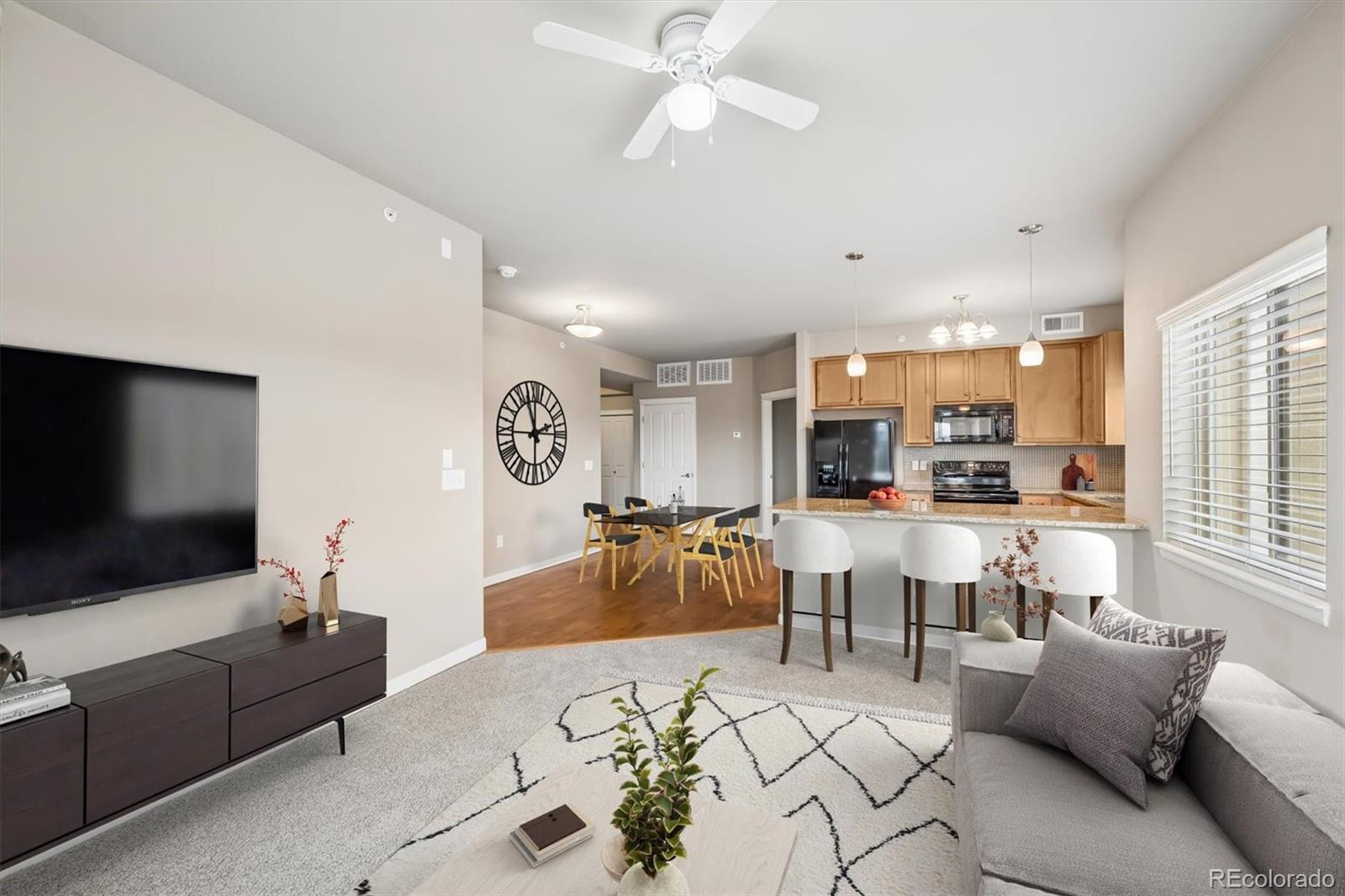 1044 Rockhurst Drive, Unit 404 Highlands Ranch, CO 80129 - Photo 3 of 28 a living room with furniture and a flat screen tv