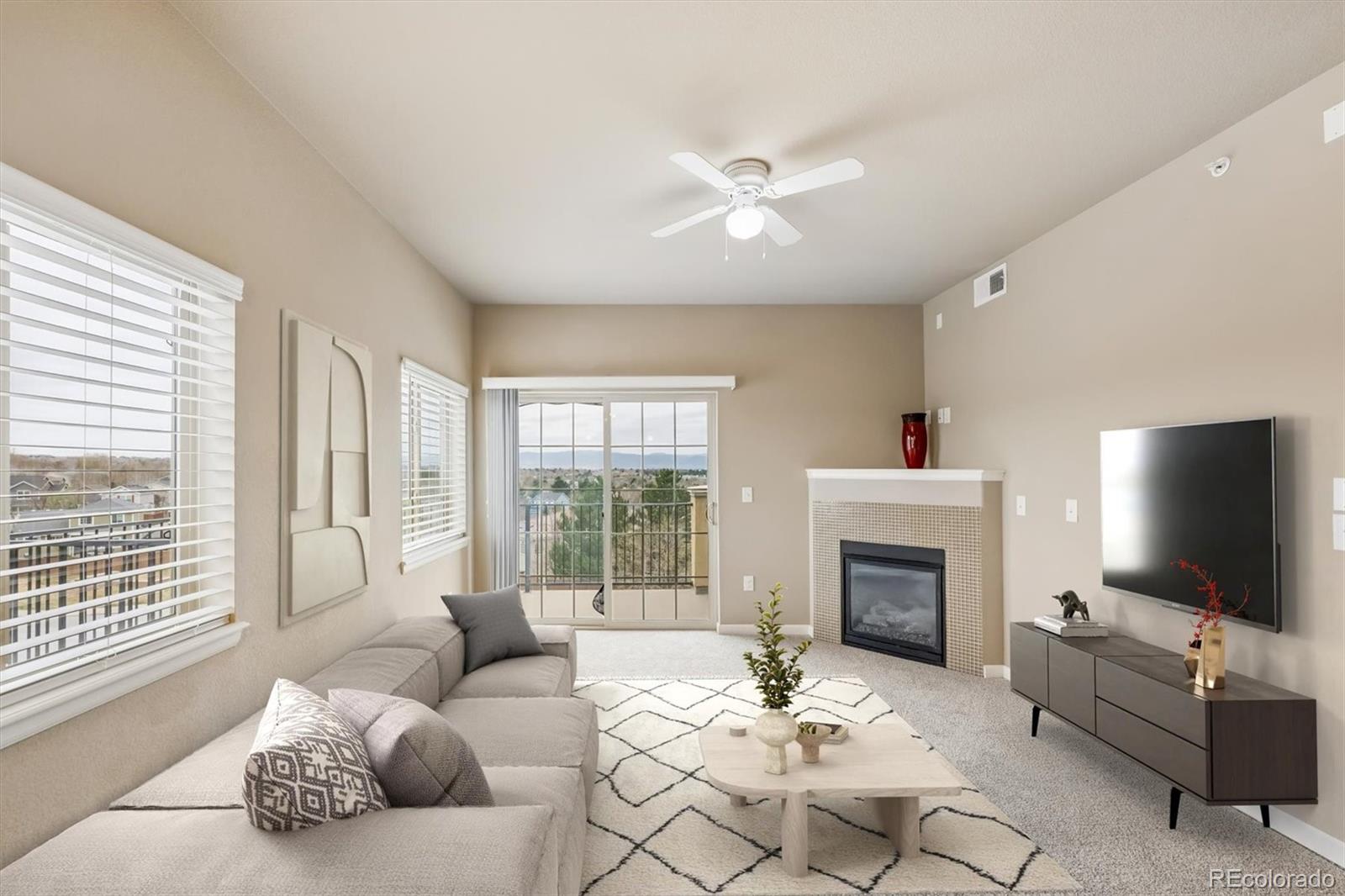 1044 Rockhurst Drive, Unit 404 Highlands Ranch, CO 80129 - Photo 5 of 28 a living room with furniture a fireplace and a flat screen tv