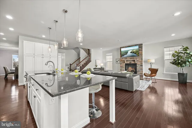 a kitchen with stainless steel appliances granite countertop wooden floors and view living room