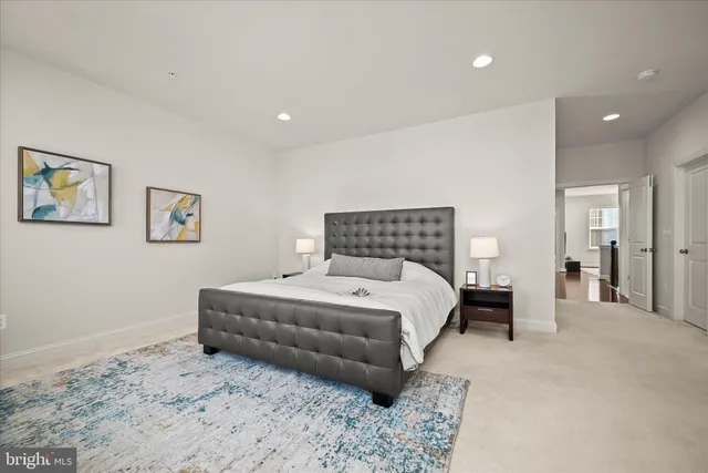 a spacious bedroom with a bed and a view of cupboard