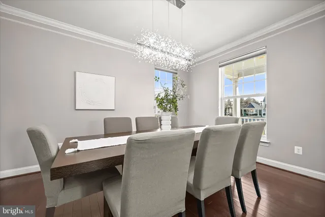 a view of a dining room with furniture a chandelier and a window