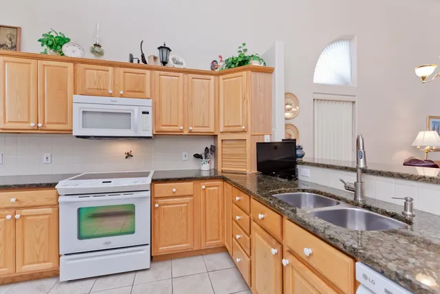 a kitchen with granite countertop a sink a stove and cabinets