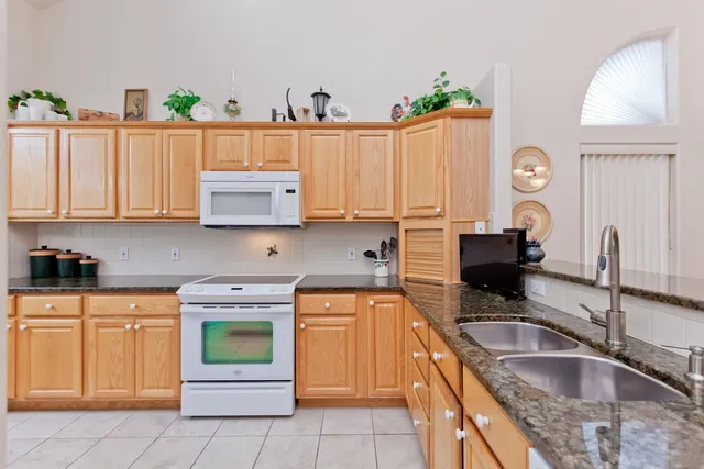 a kitchen with granite countertop a sink and a stove top oven