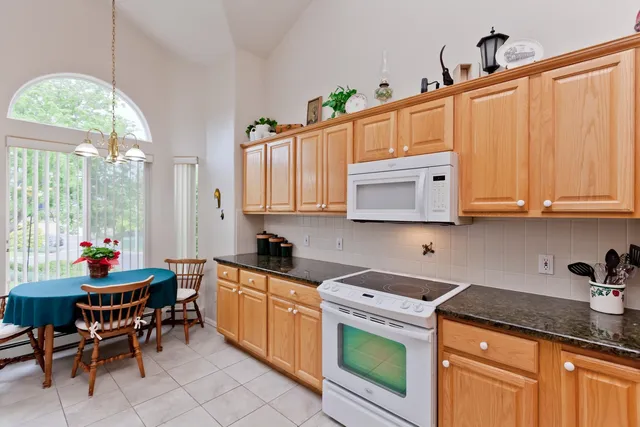 a kitchen with stainless steel appliances granite countertop a stove a sink dishwasher and cabinets with wooden floor