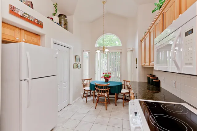 a kitchen with stainless steel appliances kitchen island granite countertop a refrigerator and a sink