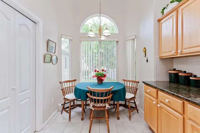a dining room with furniture a chandelier and window