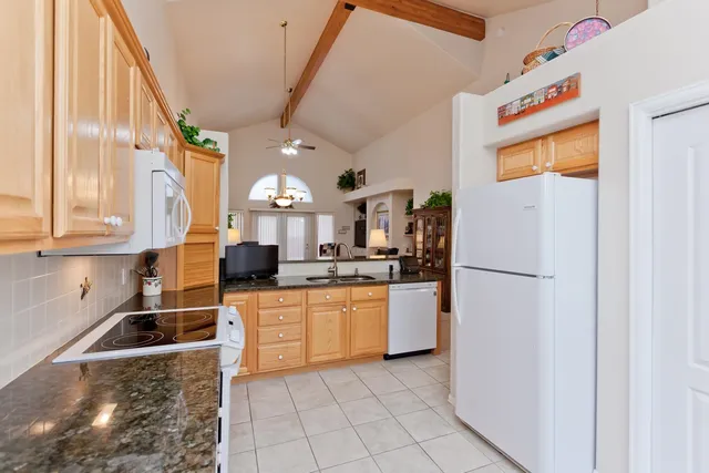 a kitchen with stainless steel appliances granite countertop a refrigerator a stove and a sink