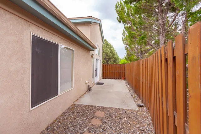 a view of a pathway of a house with wooden fence