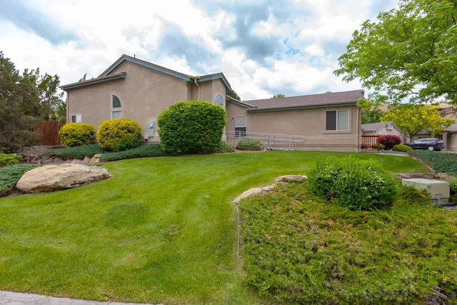 a sign of golf club on a wall under a tree