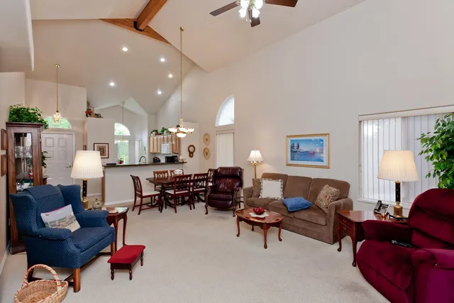 a living room with furniture kitchen view and a chandelier