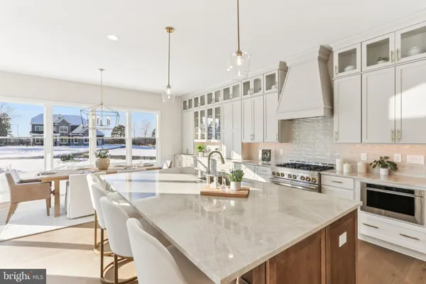 a kitchen with stainless steel appliances granite countertop a kitchen island a stove a table and chairs