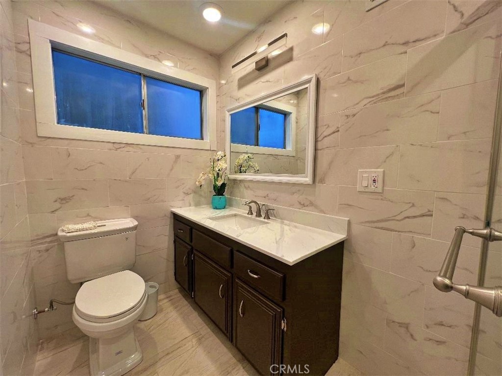 1198 Arbula Drive Crestline, CA 92325 - Photo 19 of 27 a bathroom with a toilet sink vanity and mirror