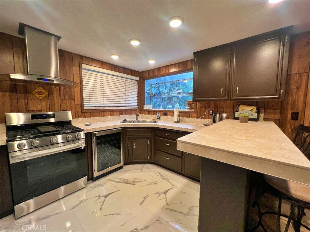 1198 Arbula Drive Crestline, CA 92325 - Photo 8 of 27 a kitchen with a stove a sink a refrigerator and chairs