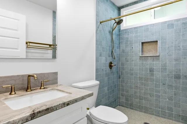 a bathroom with a sink a toilet and shower