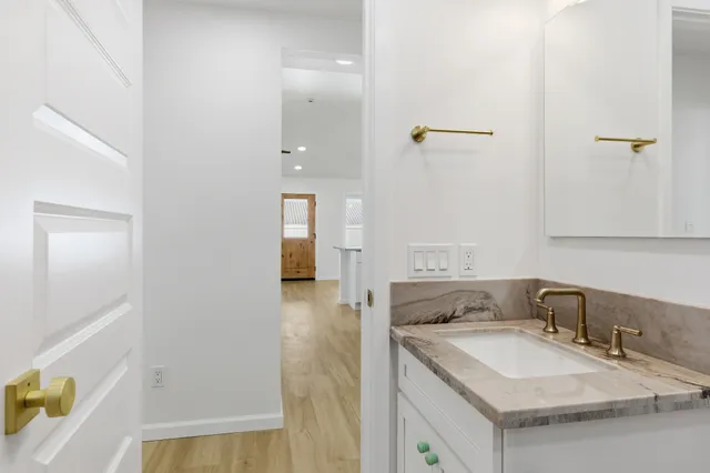 a bathroom with a granite countertop sink and a mirror
