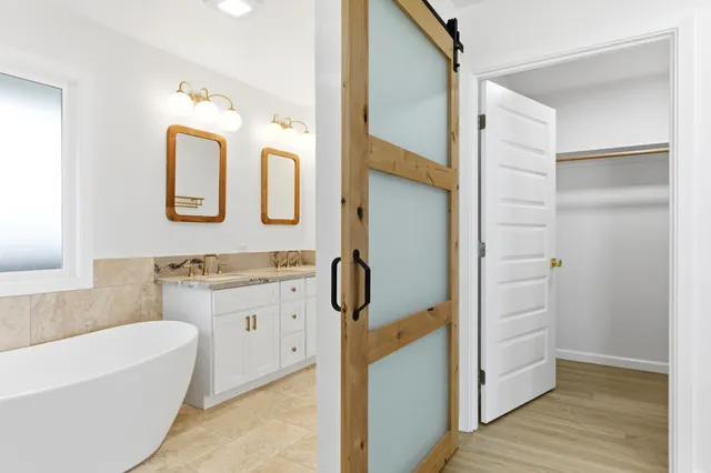 a bathroom with a tub sink and mirror