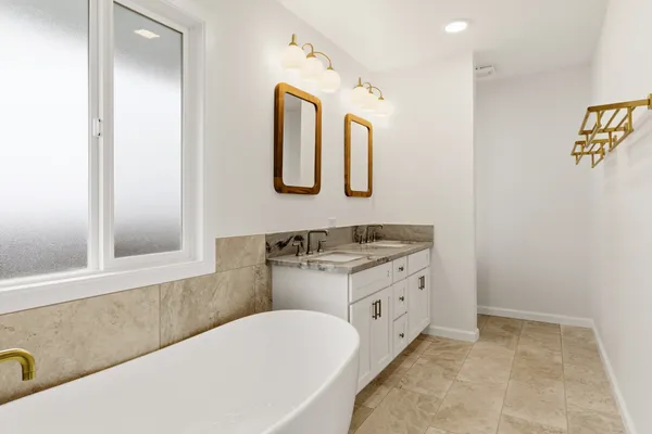 a bathroom with a tub sink and mirror