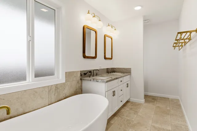 a bathroom with a tub sink and mirror