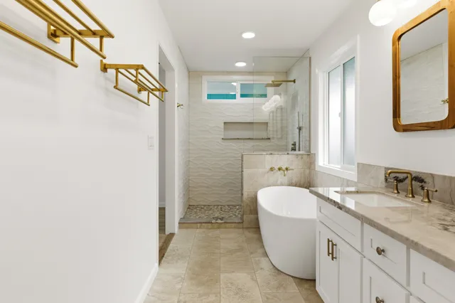 a bathroom with a granite countertop sink a toilet a mirror and shower