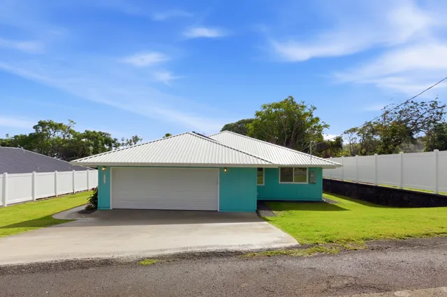 a front view of a house with a garden and yard