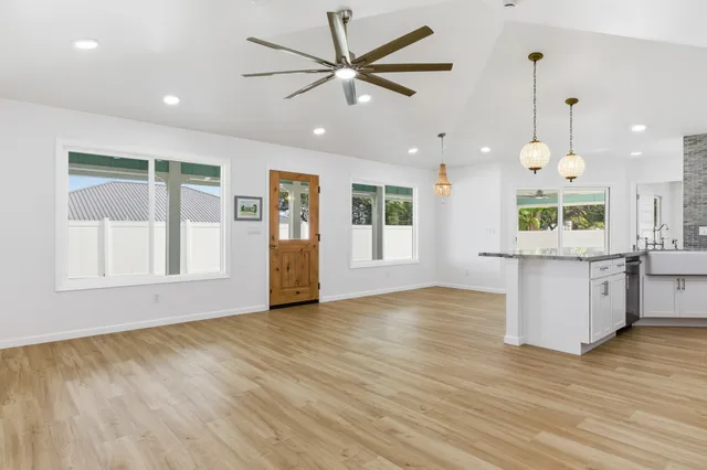 a view of an empty room with window and wooden floor